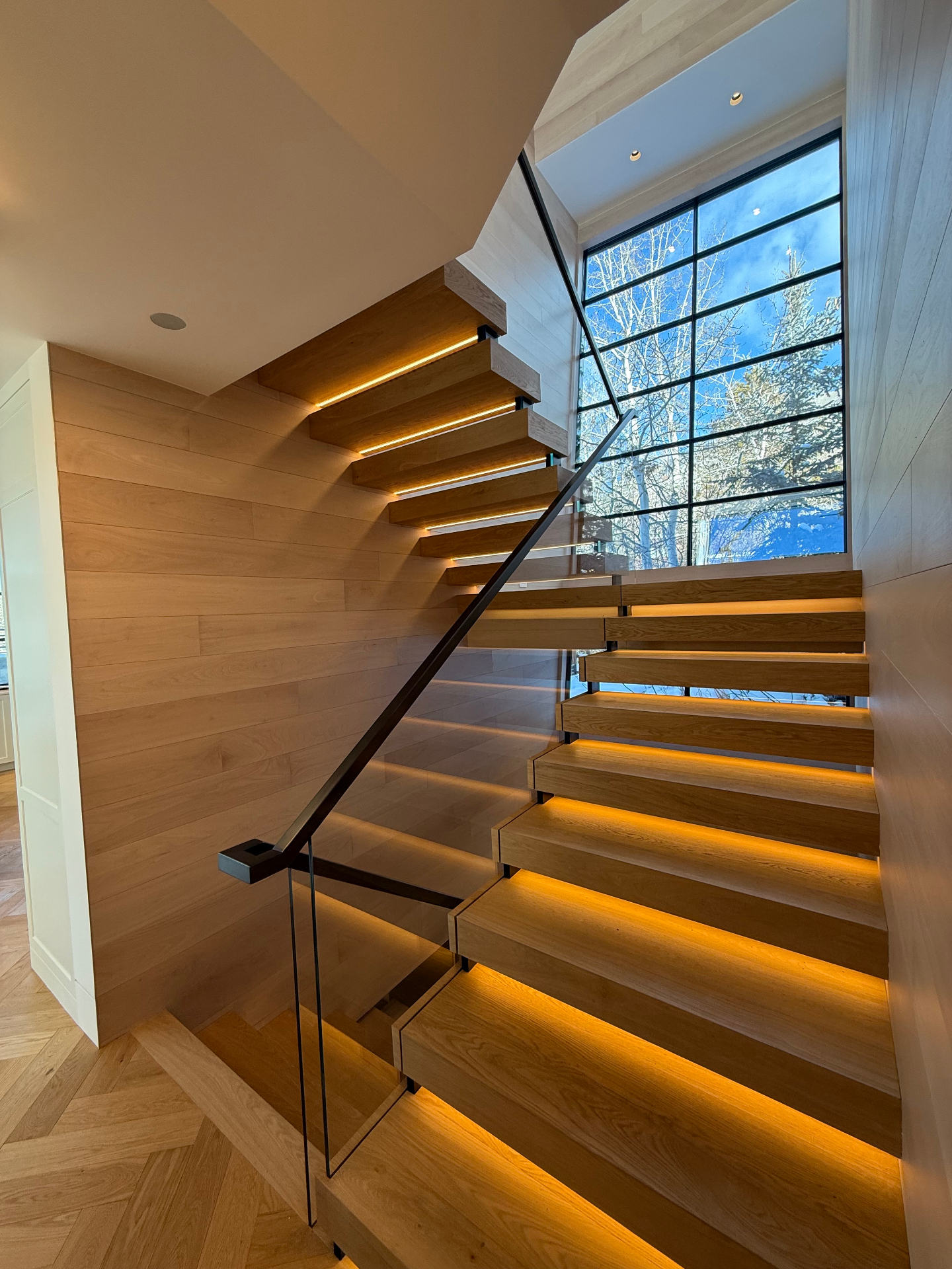 Floating oak staircase with blackened steel handrail
